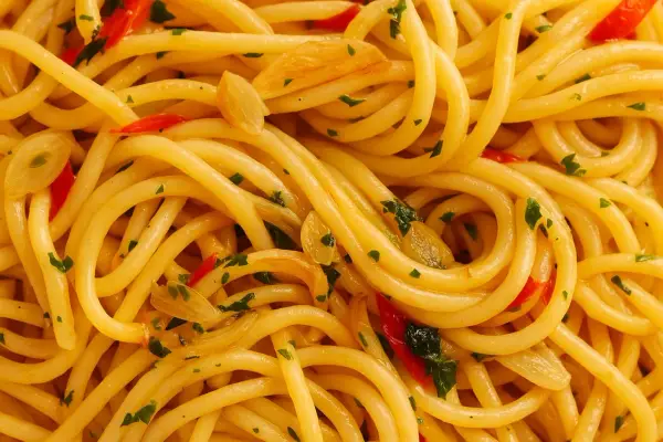 Nahaufnahme von Spaghetti Aglio e Olio, dem originalen Gericht mit Knoblauch, Chili und Petersilie.